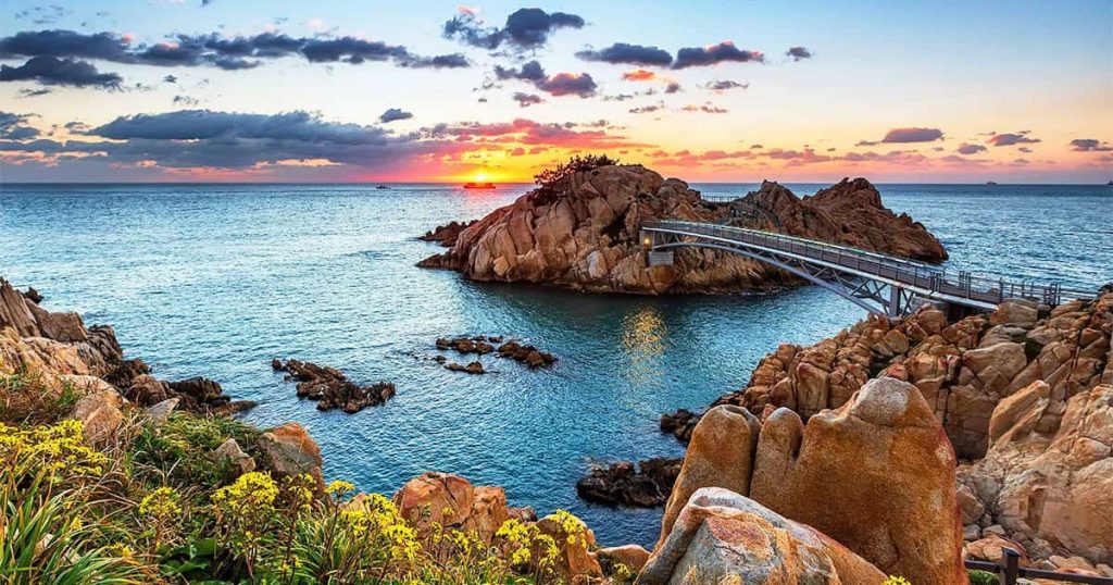 기암괴석과 푸른 바다, 그리고 하얀 등대가 조화롭게 어우러진 장면